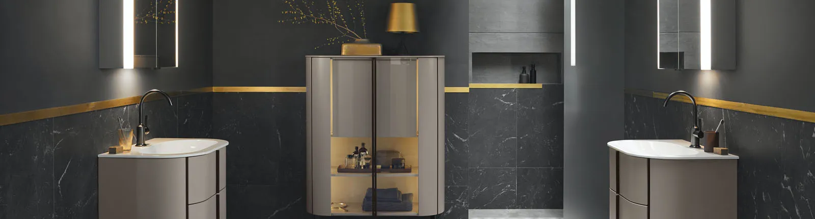 Ein stilvolles Badezimmer mit dunklem Marmordesign und goldenen Zierleisten, das zwei Waschbereiche mit geschwungenen, modernen Waschbecken umfasst. 