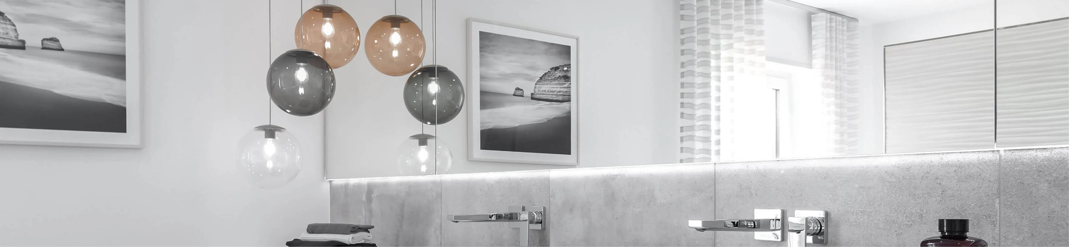 Header mit hochwertigen Pendelleuchten über einem Waschtisch in einem modernen Badezimmer.