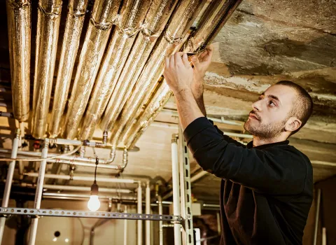 Anlagenmechaniker SHK bei der Rohrdämmung.