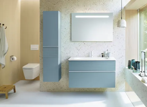 Ein modernes Badezimmer mit schwebendem Waschtisch und Hochschrank in hellblauer Farbe aus der burgbad Fiumo Kollektion.