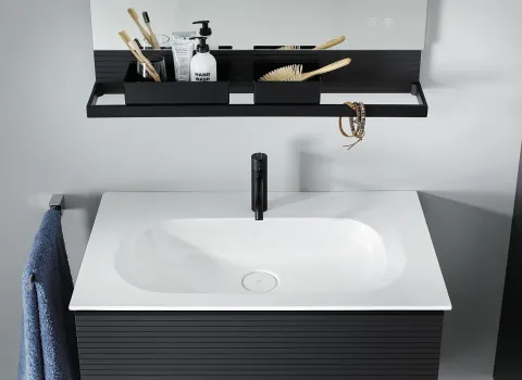 Schlichter burgbad Fiumo Waschtisch mit einem weißen Becken und einem schwarzen, matten Wasserhahn. 