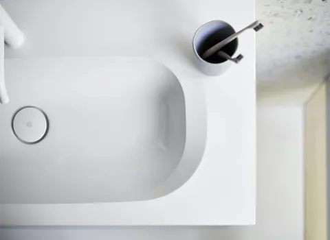 Ein weißes Waschbecken der burgbad Fiumo Serie mit abgerundeten Kanten und einem dezenten Ablaufdeckel.