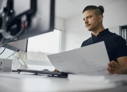 Projektleiter Heizung mit Planungsskizzen bei der Büroarbeit.
