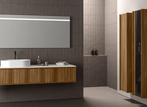 Badmöbel von Stocco mit Unterschrank in Holzoptik, schwarzer Armatur, großem Spiegel und hohem Stauraumschrank.