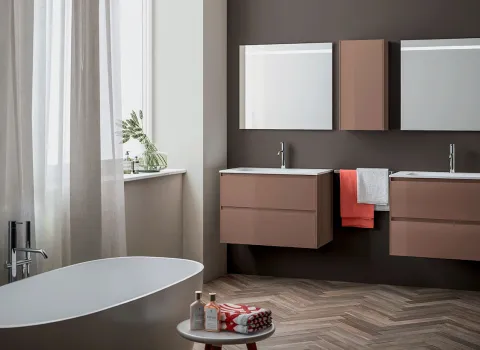 Freistehende Badewanne und wandhängende Doppelwaschtische mit modernen Badmöbeln von Stocco in warmen Naturtönen.