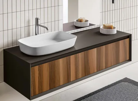 Moderner schwebender Waschtisch mit Holzfront, schwarzer Platte und Aufsatzwaschbecken im minimalistischen Bad.