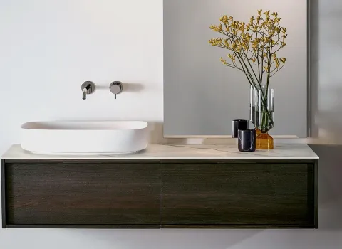 Schwebender Waschtisch aus dunklem Holz mit weißem Aufsatzbecken und minimalistischer Dekoration von Stocco.