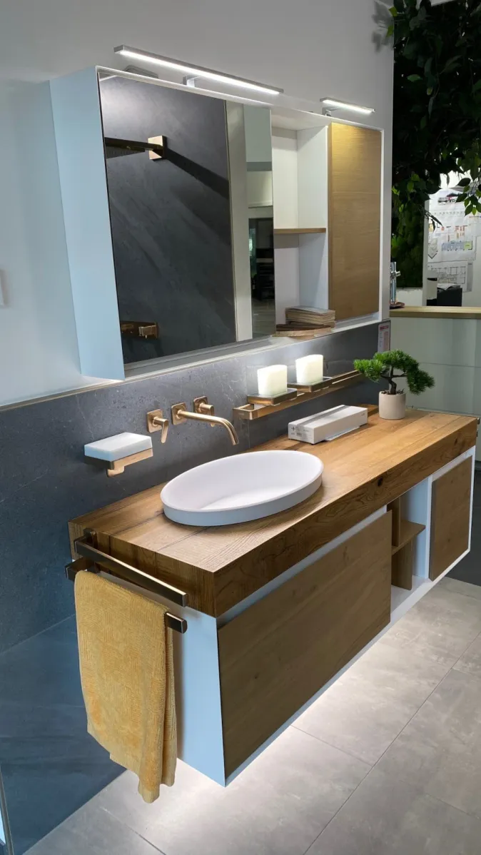 Ein modernes Badezimmermöbel mit Waschplatz kombiniert helle Holzoberflächen mit weißem Korpus und wird von einer eleganten Wandarmatur ergänzt.