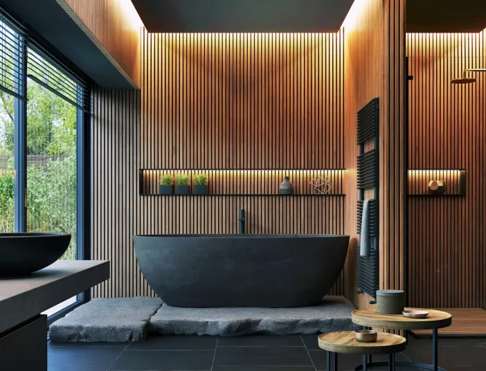 Modernes Badezimmer mit minimalistischer Ästhetik. Eine freistehende, schwarze Badewanne steht auf grob behauenen Steinplatten vor einer Wand aus senkrechten Holzlamellen.